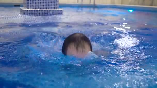 Man relaxing in swimming pool — Stock Video