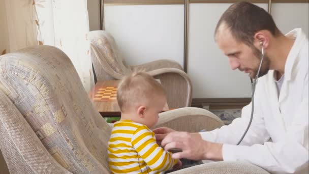 Der Arzt besucht den Säugling zu Hause. Baby mit Stethoskop — Stockvideo