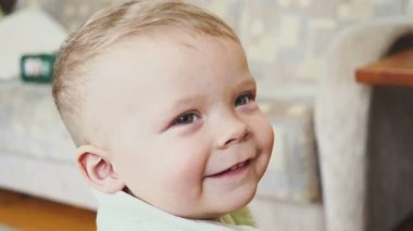 bir odada gülümseyen bir çocuk portresi