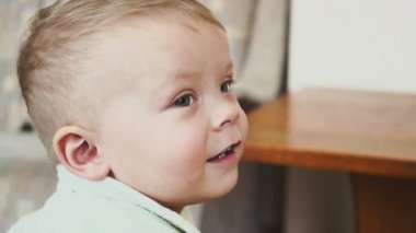 bir odada gülümseyen bir çocuk portresi