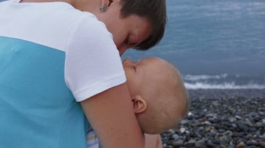 Sahilde anneler içinde uyuyan bebek eller