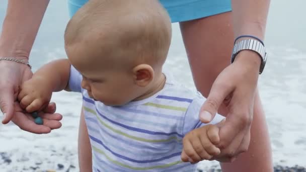 Küçük bir bebek çocuk oyun ve annesi ile Sahilde yürüyüş — Stok video
