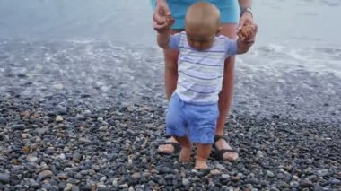 Küçük bir bebek çocuk oyun ve annesi ile Sahilde yürüyüş