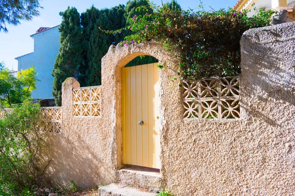 Çiçek açan çiçekler özel evin girişine yakın. İspanya güneşli gün.