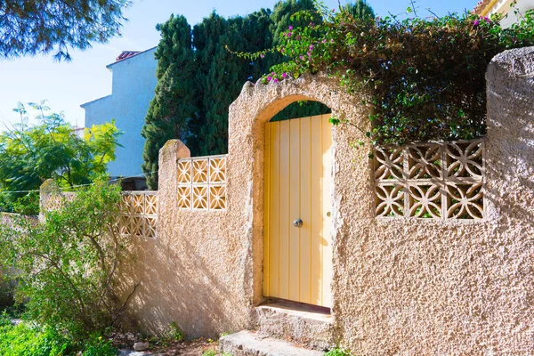 Çiçek açan çiçekler özel evin girişine yakın. İspanya güneşli gün.