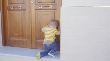 küçük oğlu deneyin bir evin ahşap kapı açmak için