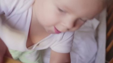 Beşik görünüyor çocukta konuşuyor, atlar ve gülümsüyor.