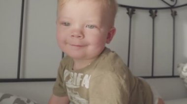 4 k yatakta bir şişe süt içerken bebek çocuk gülümseyen