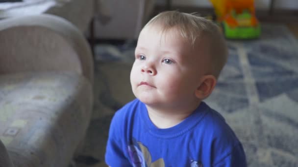 Bambino di un anno che guarda la TV - dolly shot. Ragazzino che guarda cartone animato in tv nella stanza . — Video Stock