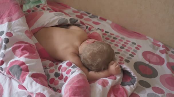 可爱的婴儿睡在他的床上在家里的房间。睡眠婴儿的概念。1岁的 babyboy 在家睡觉 — 图库视频影像