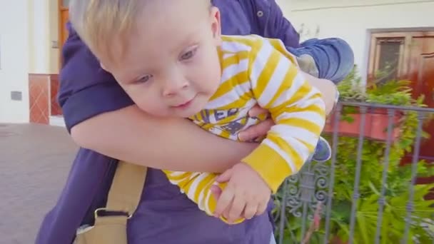 Moeder draagt haar jongetje, hij kijkt naar de Camera — Stockvideo