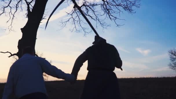 Kaszás jött egy új áldozat, és az áldozat halálhoz vezet. naplemente sziluettje. a halál fogalma — Stock videók