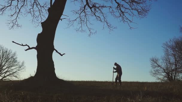 Het silhouet van de werknemers shoveling de bodem met een spade in de avond. — Stockvideo