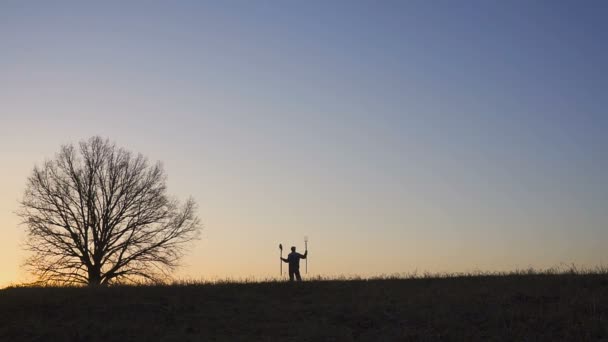 Un agricoltore soddisfatto balla nel campo. Silhouette di un tramonto o alba in campo . — Video Stock