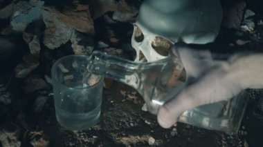 adam alkol dökülen ve kafatasının arka plan üzerinde içecekler. alkol bağımlılığı cincept. 4k