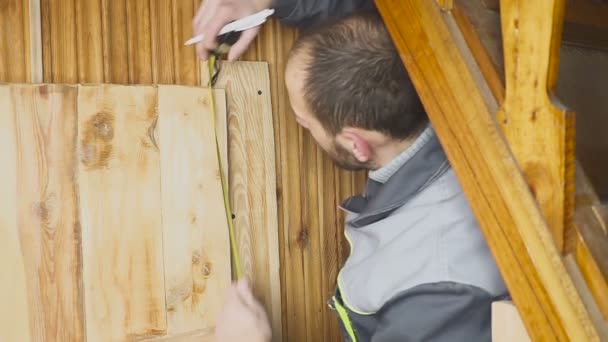 Der Arbeiter stellt eine selbstgebaute Tür in ein hölzernes Innere — Stockvideo