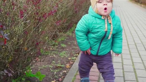 滑稽微笑1岁男孩走在公园在日落与面包在手。快乐的童年概念。慢动作 — 图库视频影像