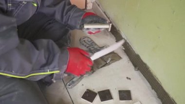 Çalışan küçük fayans mutfak duvar ayarlar. Elleri döşeme üzerinde yapışkan yerleştirir. çekim stedikam