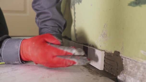 Werknemer stelt kleine tegels op de muur in de keuken. Zijn handen zijn het plaatsen van de tegel op de lijm. stedikam schieten. Closeup — Stockvideo