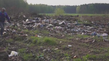 Yararlı öğeleri ve çöp dökümü çöp arasında hayatta kalmak için gıda yığınlar arayan evsiz adam. Çevre kirliliği. Yoksulluk. Çantada boş şişe olduğunu.