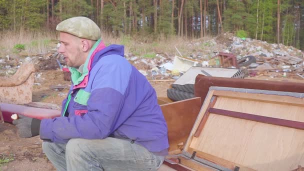 Бездомний чоловік їсть на звалищі соціальне відео — стокове відео