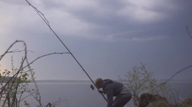 balıkçı bir göl elinde bir olta ile Balık tutma gezisinde üzerinde