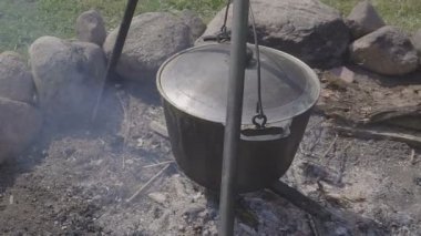 Söz konusu ormanda hazırlamak için sıcak taze yiyecek. Bir kazan ile sıcak taze çorba ya da güveç ya da yulaf lapası tehlikede. Bir ülke evin avlusuna gelsinler. Yakın çekim.