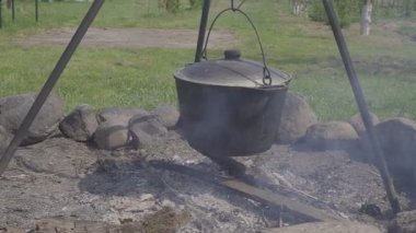 Söz konusu ormanda hazırlamak için sıcak taze yiyecek. Bir kazan ile sıcak taze çorba ya da güveç ya da yulaf lapası tehlikede. Bir ülke evin avlusuna gelsinler. Yakın çekim.
