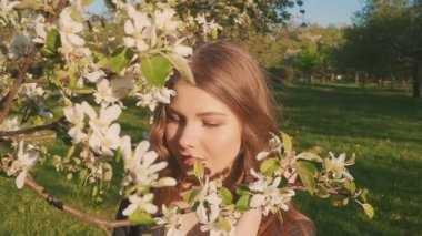 bahar çiçekleri beyaz bir elma bahçesi içinde yürüyen genç mutlu kadın. Güzel bir kadın portresi