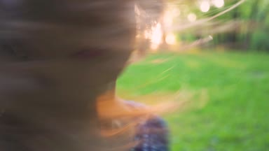 Genç çekici kız park portre saç twirls. ağır çekim
