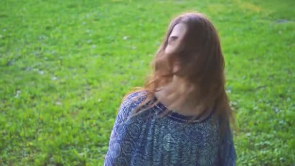 Young attractive girl twirls hair in the park closeup. slow motion — Stock Video