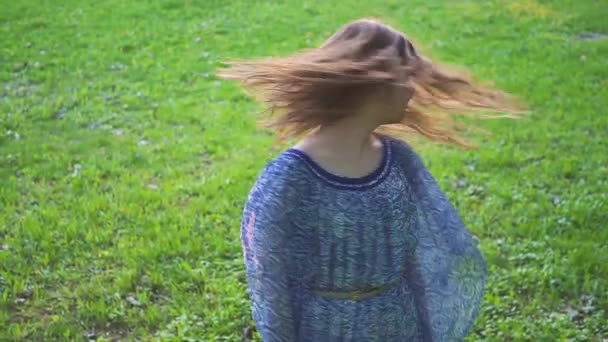 Menina atraente jovem gira cabelo no parque closeup. câmara lenta — Vídeo de Stock