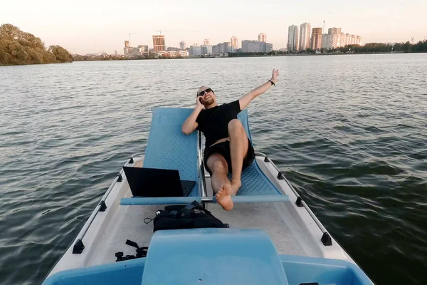 Genç çevirmen bir tekne bilgisayarda çalışır. Uzak iş. Pasif kazanç