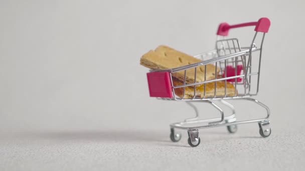 Cookies vallen in de kar van de supermarkt. Kerst cookie binnen supermarkt kar — Stockvideo