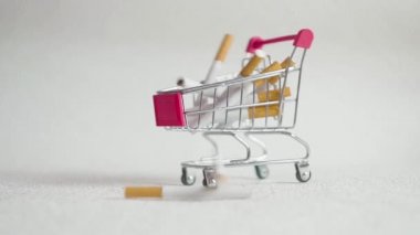 Alışveriş sepeti içinde sigarası. Süpermarket arabası içinde sigarası. Sağlık ve bağımlılık kavramı.