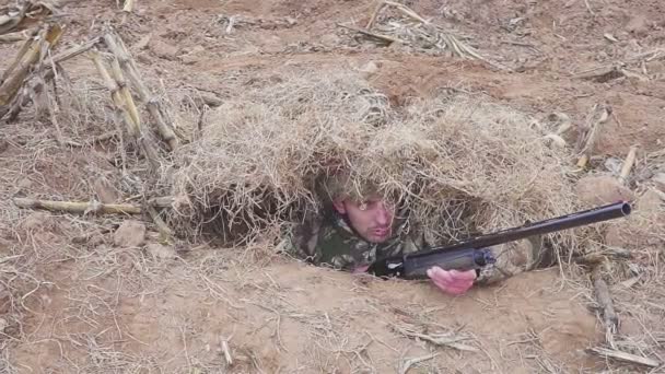 Goose Hunter verstopt in het droge gras met een jachtgeweer in zijn handen — Stockvideo