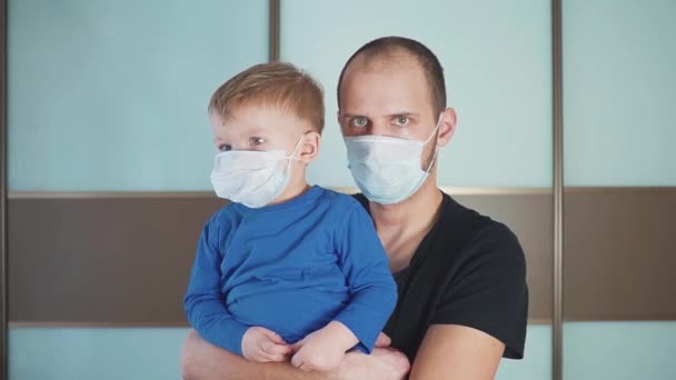 Vader en zoon staan in kliniek met medisch masker — Stockvideo