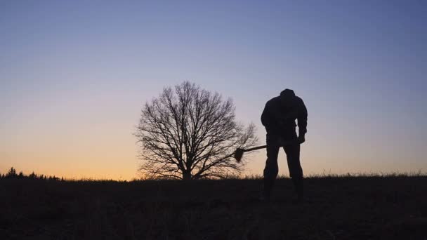 La silueta de los trabajadores paleando el suelo con una pala por la noche . — Vídeos de Stock