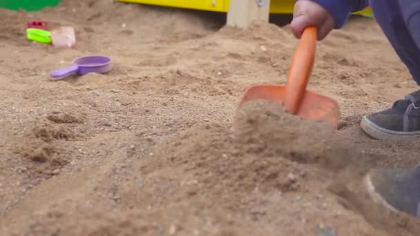 キッズゲーム。サンド ボックスで掘りの男の子。笑顔し、砂に触れる. — ストック動画