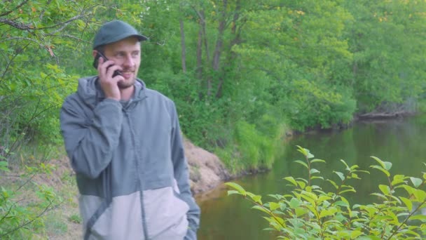 L'uomo sta facendo una chiamata, parlando con qualcuno e sorridendo, clicca sul telefono . — Video Stock