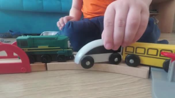 Three years old child boy play with train, build toy railroad at home. — 비디오