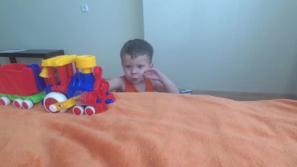 Dreijähriger Junge spielt mit Zug, baut zu Hause Spielzeugeisenbahn. — Stockvideo