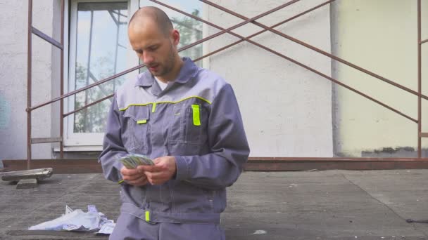 Constructor contando su salario de pie en el sitio de construcción — Vídeos de Stock