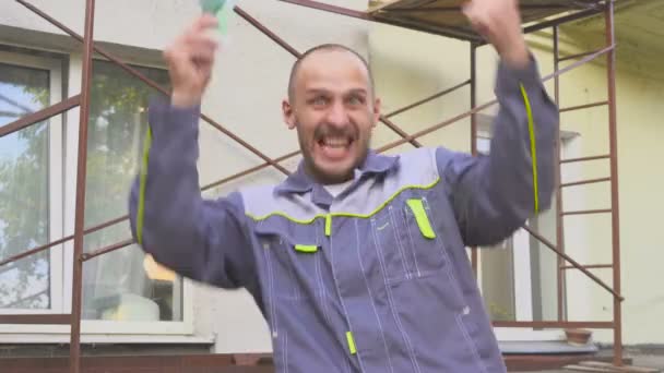 Emocjonalne szczęśliwy builder z dużo pieniędzy euro na zewnątrz. — Wideo stockowe