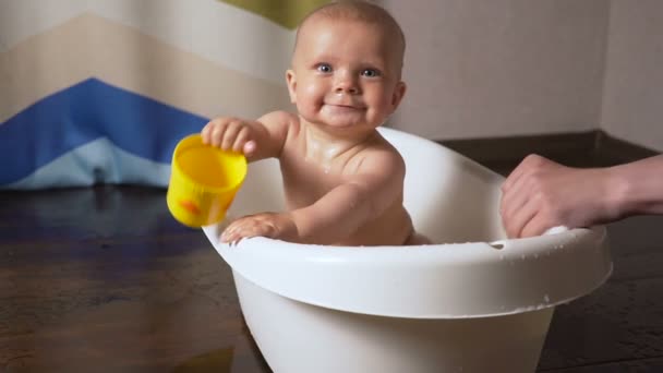 Pasgeboren baby is bedekt met water drops close-up spelen en glimlachend in het bad — Stockvideo