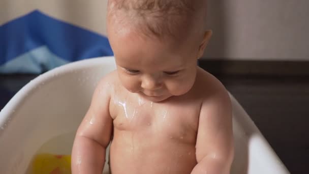 Pasgeboren baby is bedekt met water drops close-up spelen en glimlachend in het bad — Stockvideo