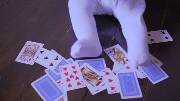 Новорожденный играет в игральные карты в комнате — стоковое видео