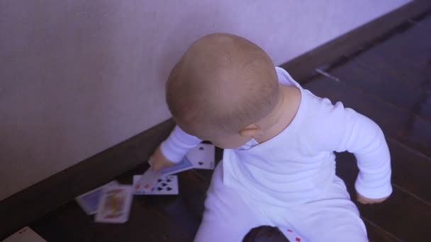 Bebê recém-nascido joga as cartas de jogo na sala — Vídeo de Stock