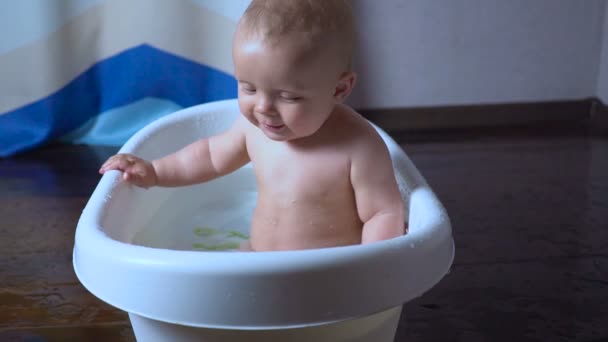 Nyfött barn leker och leende i badet — Stockvideo