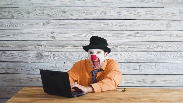Ofis işçisi palyaço, iş yerinde palyaço kavramı. Bilgisayarda iş adamı, bir dizüstü bilgisayar üzerinde çalışmak.